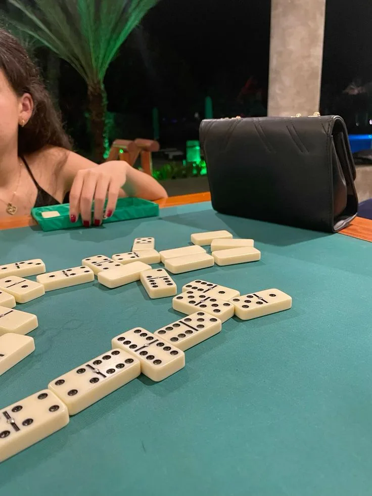 Fichas de dominó formando una cadena sobre un tapete verde
