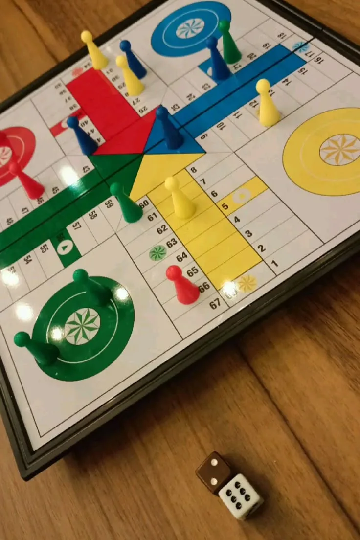 Tablero de parchís con fichas de colores y un dado